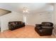 Bright living room features tile flooring, ceiling fan, and comfortable leather furniture at 5607 Tanagergrove Way, Lithia, FL 33547