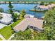 Stunning aerial view of waterfront home with tile roof, screened pool, private dock, and lush landscaping at 5818 Cruiser Way, Tampa, FL 33615