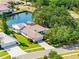 Stunning aerial view of a waterfront home with lush greenery and tile roof at 5818 Cruiser Way, Tampa, FL 33615