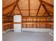 Spacious attic space featuring plywood walls, wooden support beams, concrete flooring, and additional storage shelving at 5818 Cruiser Way, Tampa, FL 33615