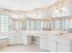 Bathroom featuring a vanity with double sinks, a large mirror, glass block windows, a tub and a glass shower at 5818 Cruiser Way, Tampa, FL 33615