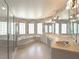 Bright bathroom featuring a vanity with double sinks, a large mirror, glass block windows, a tub and a glass shower at 5818 Cruiser Way, Tampa, FL 33615