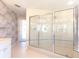 Bathroom featuring a standalone shower with glass doors and unique patterned wall coverings at 5818 Cruiser Way, Tampa, FL 33615
