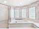 Bathroom featuring a standalone shower and tub with glass block windows and unique patterned wall coverings at 5818 Cruiser Way, Tampa, FL 33615