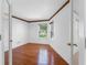 Bedroom featuring hardwood floors, a window, light walls, and white trim with decorative accents at 5818 Cruiser Way, Tampa, FL 33615