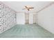 Bedroom with floral wallpaper, green carpet, and a view into the bathroom through the hallway at 5818 Cruiser Way, Tampa, FL 33615