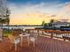Waterfront deck at sunset, furnished with outdoor seating for enjoying the view at 5818 Cruiser Way, Tampa, FL 33615