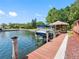 Waterfront property featuring a private dock with boat lift, gazebo and easy water access at 5818 Cruiser Way, Tampa, FL 33615
