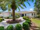 Beautiful home exterior with lush landscaping, mature palms, and circular paver driveway at 5818 Cruiser Way, Tampa, FL 33615