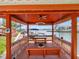 Covered waterfront gazebo on a private dock, featuring a picnic table, ceiling fan, and swing at 5818 Cruiser Way, Tampa, FL 33615