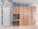 A bright laundry room features a white door, wooden cabinets, and granite countertop desk with tropical wallpaper at 5818 Cruiser Way, Tampa, FL 33615