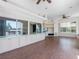 Expansive living room featuring tiled floors, a spiral staircase, and wide windows showcasing lake views at 5818 Cruiser Way, Tampa, FL 33615