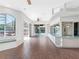 Spacious living room with wood-look flooring, bar seating, and access to a pool and outdoor patio via sliding doors at 5818 Cruiser Way, Tampa, FL 33615