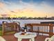 Cozy outdoor dining area overlooking the water with a bottle of wine and a cheese plate at 5818 Cruiser Way, Tampa, FL 33615