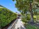 Waterfront home with lush landscaping and stone pathway leading to a charming covered dock gazebo at 5818 Cruiser Way, Tampa, FL 33615