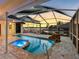 Tranquil screened pool and spa area with stone waterfall feature, sunset views, and covered patio at 5818 Cruiser Way, Tampa, FL 33615
