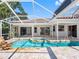 Waterfront home featuring a pool with lanai, spa and waterfall at 5818 Cruiser Way, Tampa, FL 33615