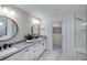 Modern bathroom featuring double sinks, black hardware, and a marble tiled walk-in shower at 5949 Bluestar Ct, Lakewood Ranch, FL 34211