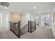 Hallway with metal railing staircase leads to the open living space and bright bedrooms at 5949 Bluestar Ct, Lakewood Ranch, FL 34211