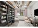 Bright home office features custom shelving, wooden ceiling beams, contemporary lighting, and a large window at 5949 Bluestar Ct, Lakewood Ranch, FL 34211