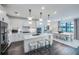 Open concept kitchen with island, dining area, stainless steel appliances, and modern lighting at 5949 Bluestar Ct, Lakewood Ranch, FL 34211