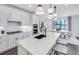 Bright kitchen with white cabinets, island with seating, and view to dining area at 5949 Bluestar Ct, Lakewood Ranch, FL 34211