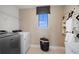Functional laundry room featuring modern appliances, storage shelves, and a bright window at 5949 Bluestar Ct, Lakewood Ranch, FL 34211