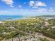 Aerial view of the home in relation to the surrounding landscape with the ocean in the distance at 612 Ozona Village Dr, Palm Harbor, FL 34683