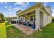 Expansive backyard showcases a covered patio, outdoor seating, a grill, and lush greenery, perfect for outdoor entertaining at 612 Ozona Village Dr, Palm Harbor, FL 34683