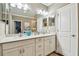 Bright bathroom features a double sink vanity, and decorative accents; a storage closet is visible through the mirror at 612 Ozona Village Dr, Palm Harbor, FL 34683