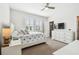 Comfortable bedroom featuring neutral tones, ceiling fan, shutters, and large dresser with a TV at 612 Ozona Village Dr, Palm Harbor, FL 34683