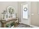 Welcoming foyer with decoratively adorned mirror, rustic wood table and frosted door at 612 Ozona Village Dr, Palm Harbor, FL 34683