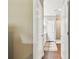 Hallway with hardwood floors leading to a bathroom with a glass-enclosed shower at 612 Ozona Village Dr, Palm Harbor, FL 34683