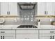 Modern kitchen featuring white cabinets, stainless appliances, and stylish subway tile backsplash at 612 Ozona Village Dr, Palm Harbor, FL 34683