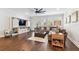 Well-lit living room showcasing hardwood floors, a large sectional sofa, and a barn door entertainment center at 612 Ozona Village Dr, Palm Harbor, FL 34683