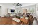 Inviting living room featuring hardwood floors, a ceiling fan, natural light, and comfortable seating at 612 Ozona Village Dr, Palm Harbor, FL 34683