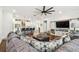 Open-concept living room with hardwood floors and kitchen with white cabinets and a large island at 612 Ozona Village Dr, Palm Harbor, FL 34683