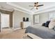 Relaxing bedroom with a tray ceiling, ceiling fan, and shuttered windows creates a luxurious retreat at 612 Ozona Village Dr, Palm Harbor, FL 34683