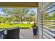 Covered patio with pavers offers a cozy outdoor seating area with a view of the spacious, lush green backyard at 612 Ozona Village Dr, Palm Harbor, FL 34683