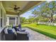 Inviting covered patio features comfortable seating overlooking a serene pond and expansive green lawn, perfect for relaxation at 612 Ozona Village Dr, Palm Harbor, FL 34683