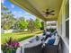 Paver patio includes comfortable seating, colorful planters, and lush landscaping overlooking a spacious and manicured backyard at 612 Ozona Village Dr, Palm Harbor, FL 34683