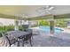 Outdoor patio with ceiling fans, chairs, and tables overlooking the community pool at 612 Ozona Village Dr, Palm Harbor, FL 34683