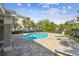 A beautiful blue swimming pool, surrounded by lounge chairs on a brick deck at 612 Ozona Village Dr, Palm Harbor, FL 34683