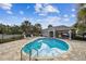 Community pool with patio, lounge chairs, and a covered seating area for relaxing and entertaining outdoors at 612 Ozona Village Dr, Palm Harbor, FL 34683