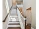Staircase showcasing hardwood treads, white risers, and a dark wood banister leading to the upper level at 612 Ozona Village Dr, Palm Harbor, FL 34683