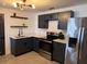 Modern kitchen featuring granite counters, stainless appliances, and sleek black cabinets at 620 Lithia Pinecrest Rd, Brandon, FL 33511