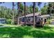 Home and backyard with deck, grill, patio furniture and green lawn at 6341 Discovery Ln, Land O Lakes, FL 34638