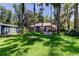 View of the backyard showing the home and blue outbuilding, and a spacious lawn at 6341 Discovery Ln, Land O Lakes, FL 34638