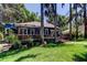 Backyard with trees, lawn, deck and blue home with metal roof at 6341 Discovery Ln, Land O Lakes, FL 34638
