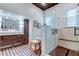 Stylish bathroom featuring dual vanity, glass shower with bench, and eye-catching patterned tile floor at 6341 Discovery Ln, Land O Lakes, FL 34638